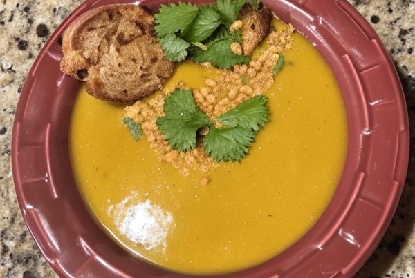 Bowl of curried pumpkin goat cheese soup topped with cilantro