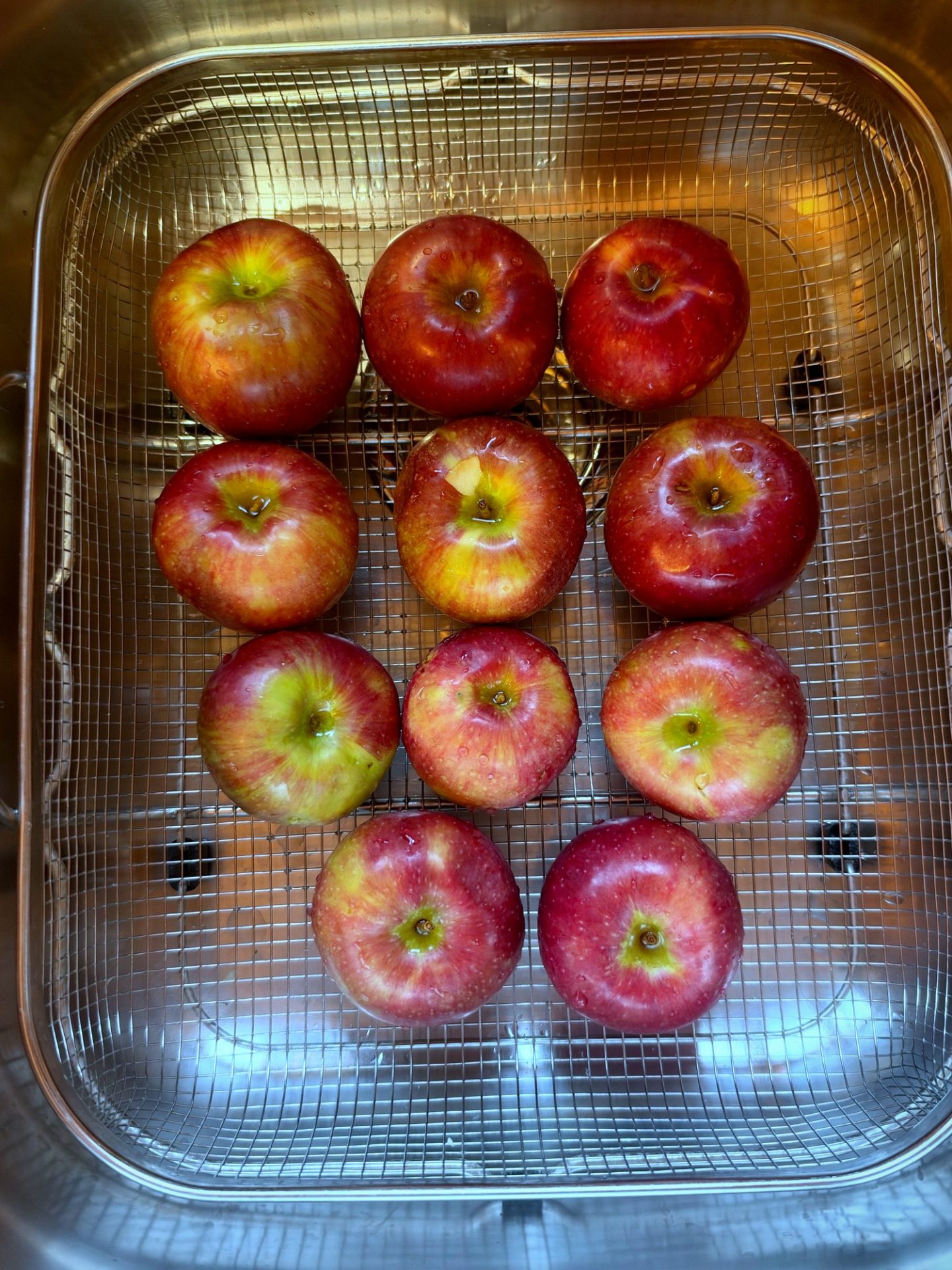 Washed red apples draining in a wire basket