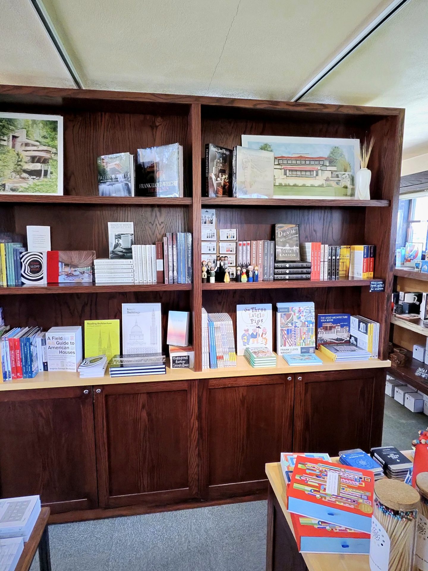 Bookstore shelf with Fallingwater framed print and Frank Lloyd Wright architecture books at Westcott House