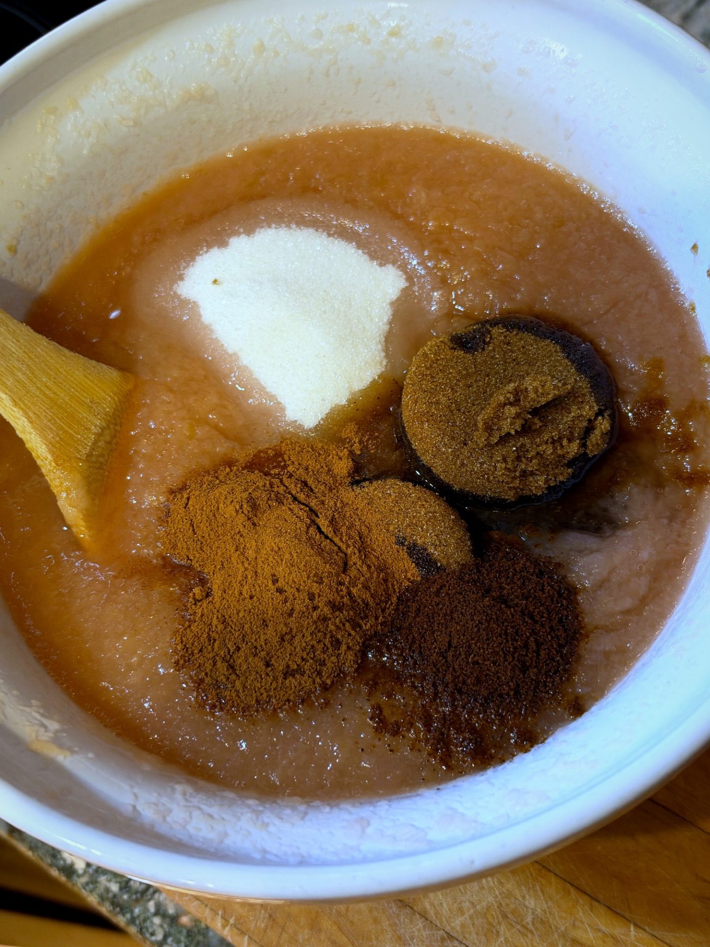 Brown sugar, white sugar, cinnamon and cloves on top of apple pulp