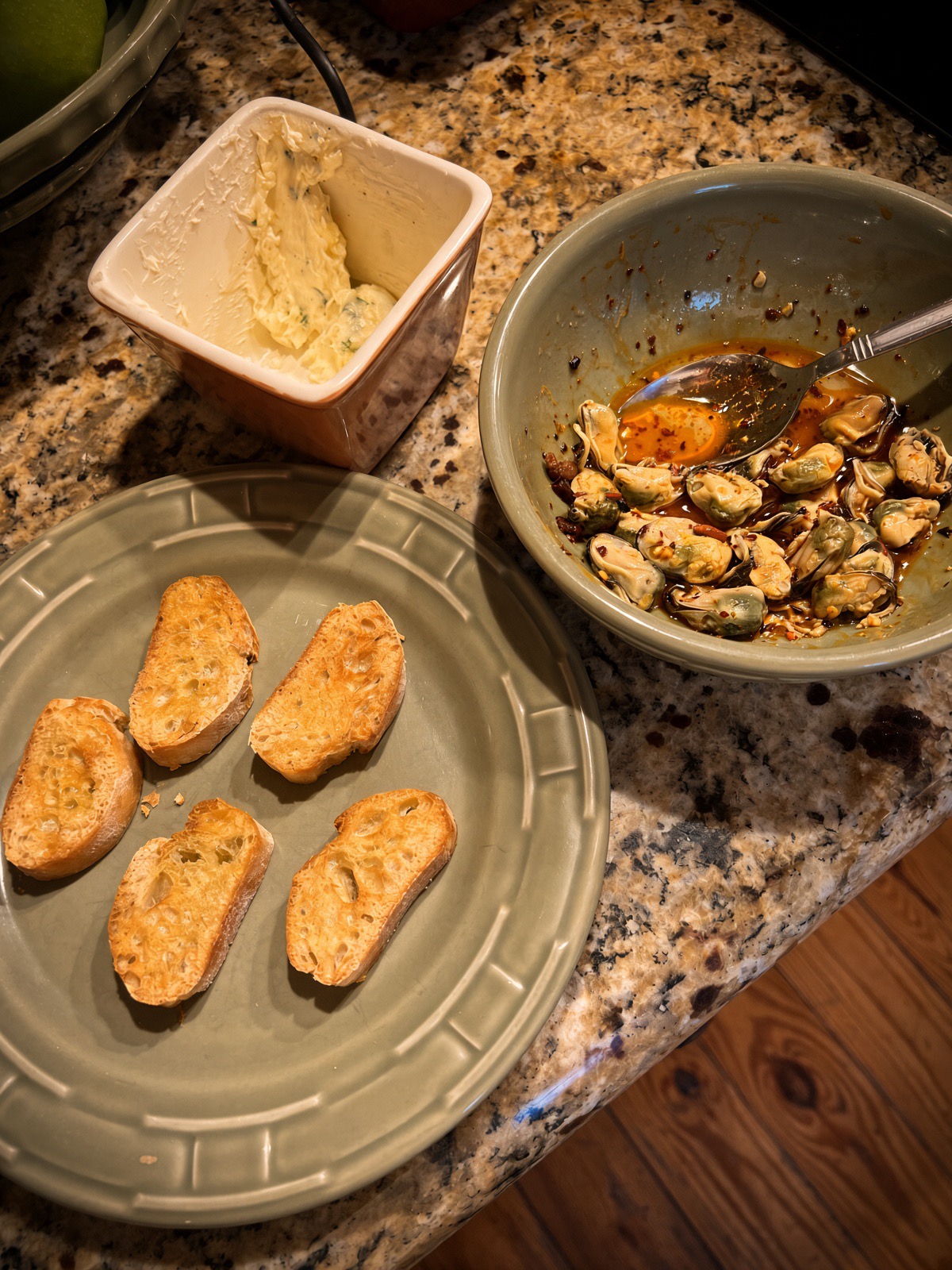 Toasted crostini, garlic herb butter and chili crisp mussels ready for assembly