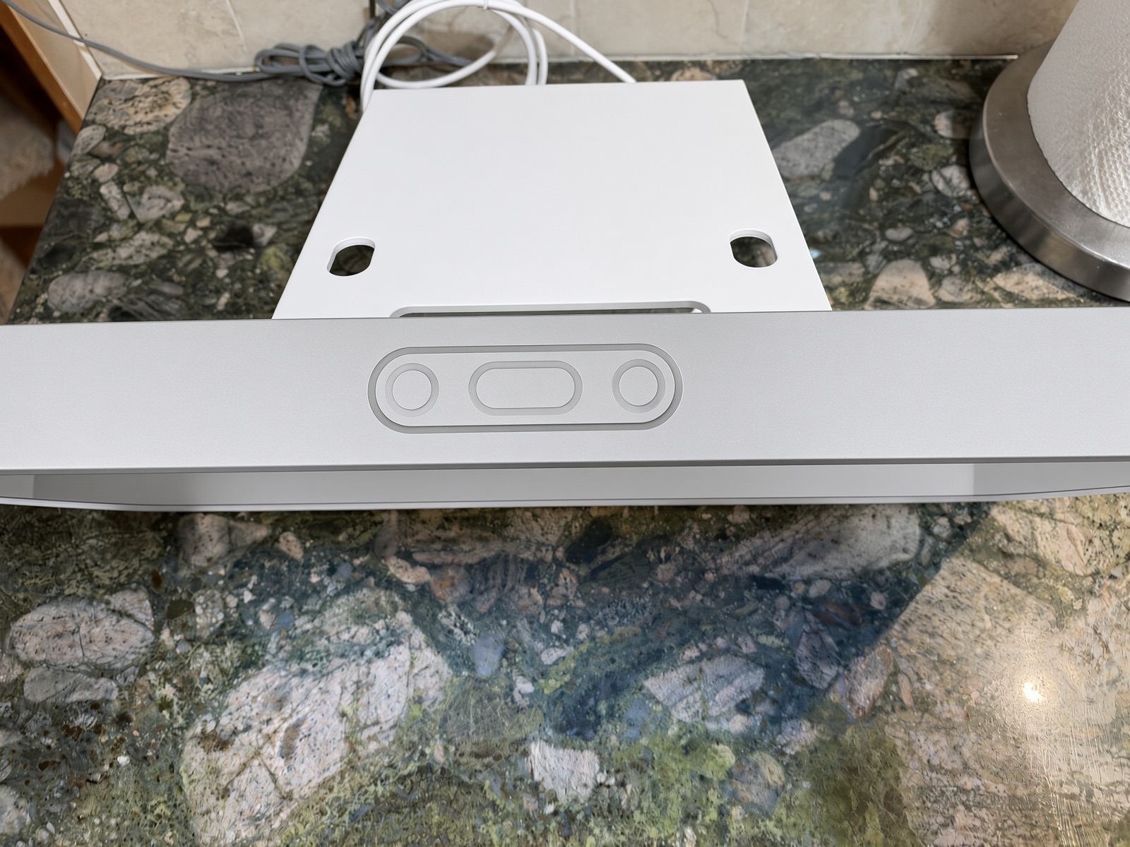 Top edge of the Skylight Calendar with its three physical buttons, seen from above on a granite counter