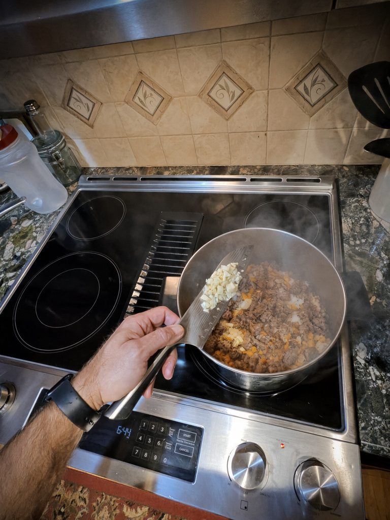 Minced garlic added to the sausage and vegetables