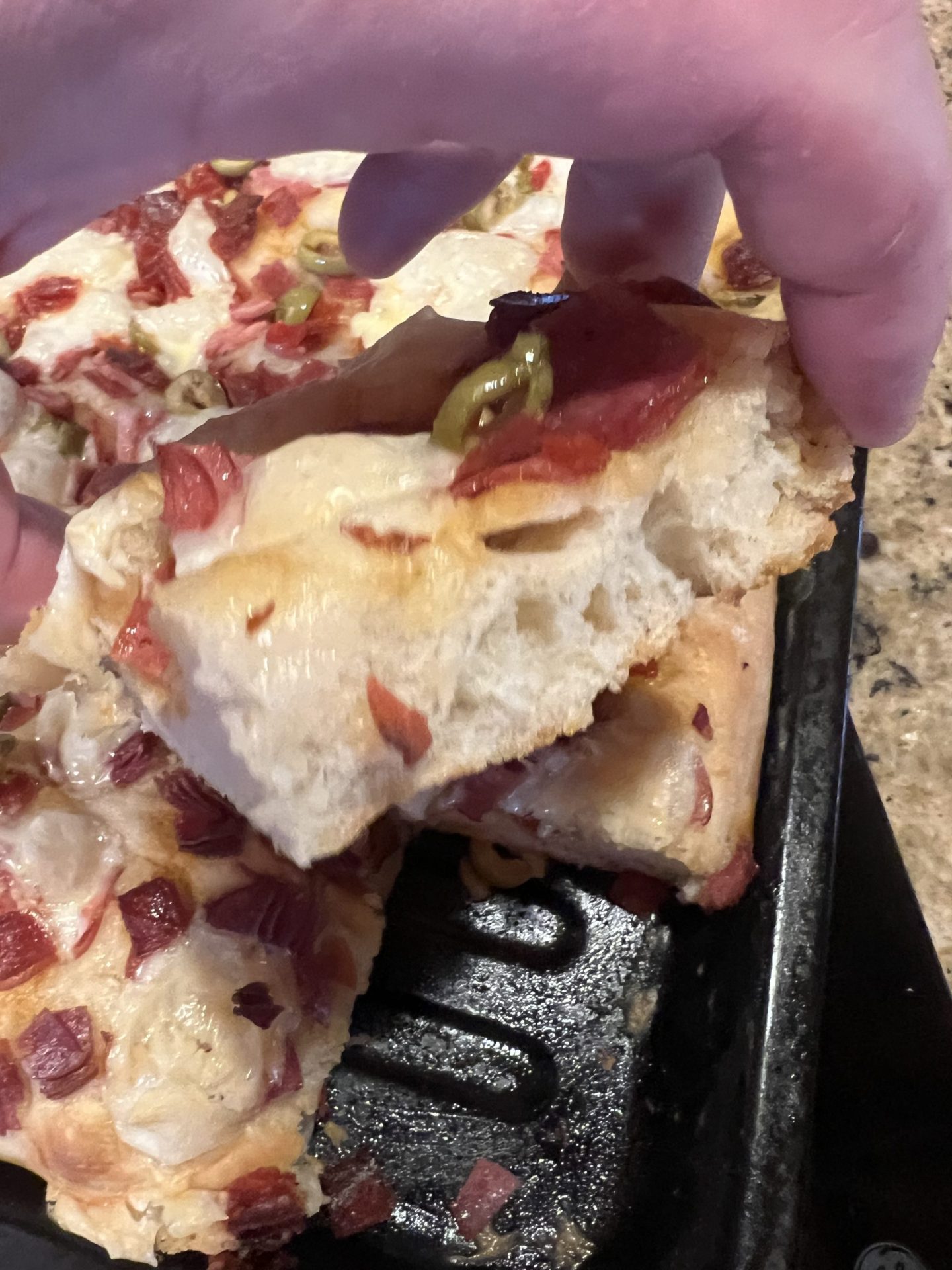 Pap Steve lifting a slice of Italian focaccia