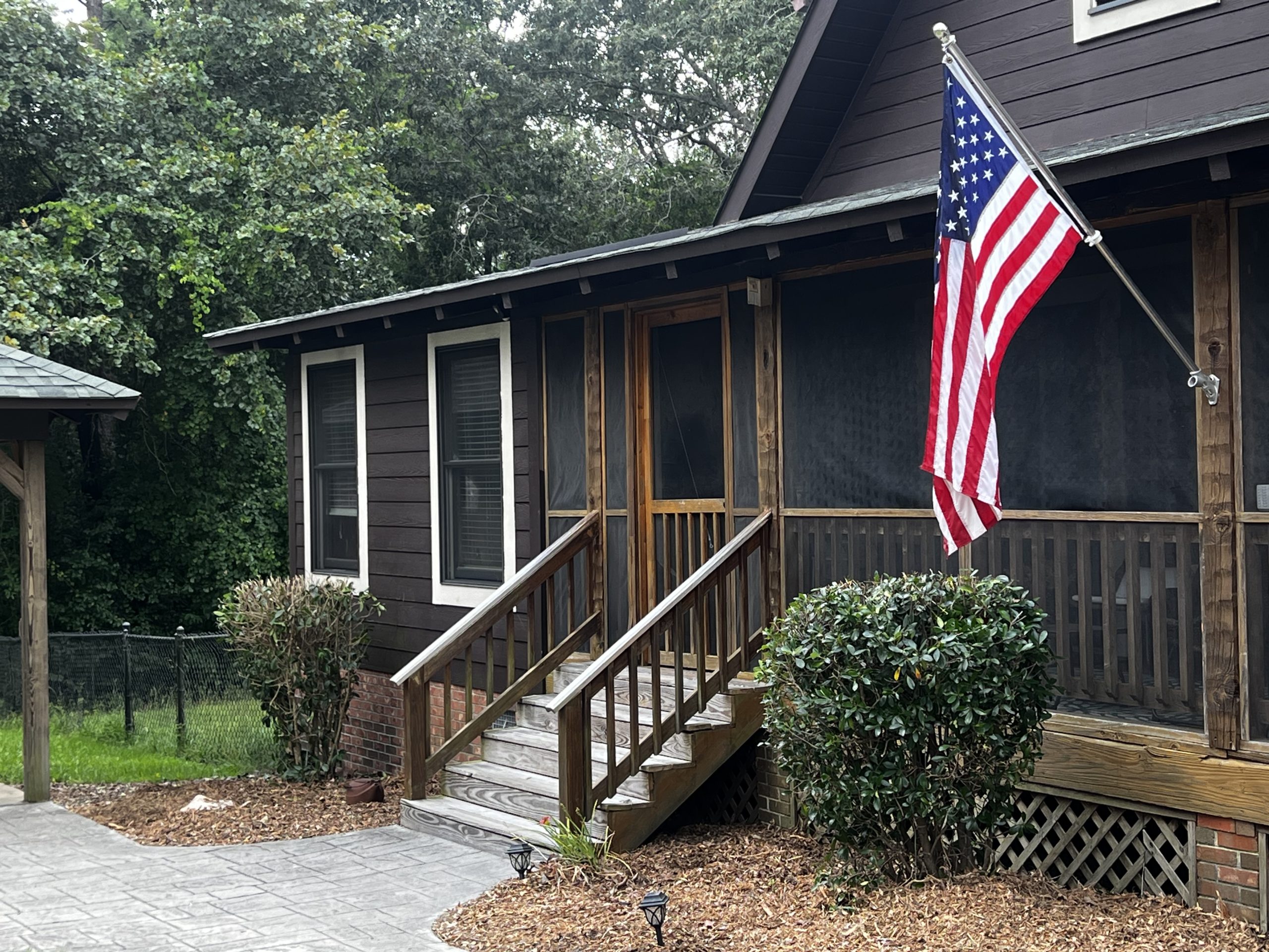 Front steps and porch of Brandowdale South with an American flag in Blythewood, SC