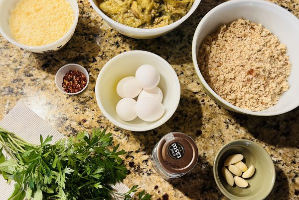 Eggplant ball ingredients laid out: eggplant, breadcrumbs, Parmesan, eggs, garlic, parsley and red pepper flakes