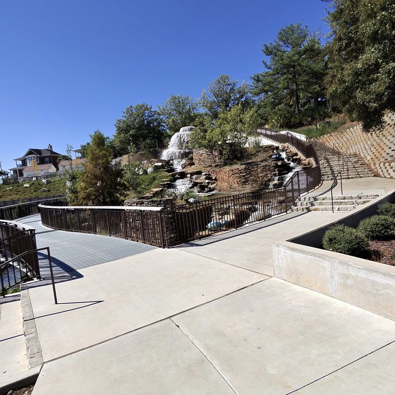 Curving walkway and railing below the stone waterfall at Finlay Park in Columbia, SC