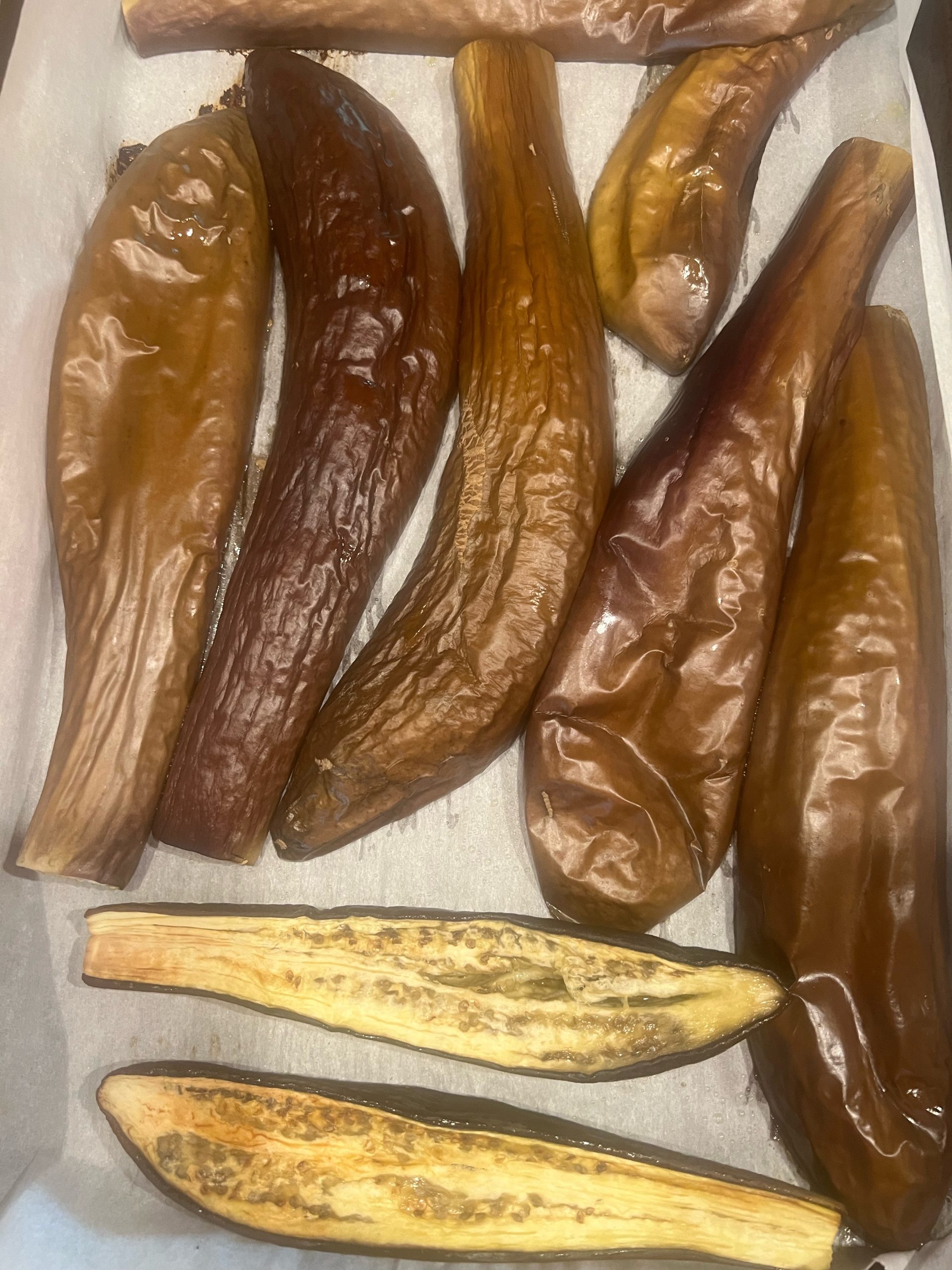 Close-up of soft roasted eggplant halves with golden caramelized flesh