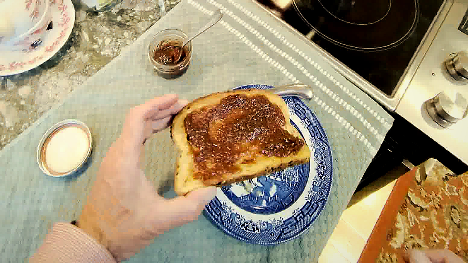 Toast with homemade apple butter lifted and about to be eaten